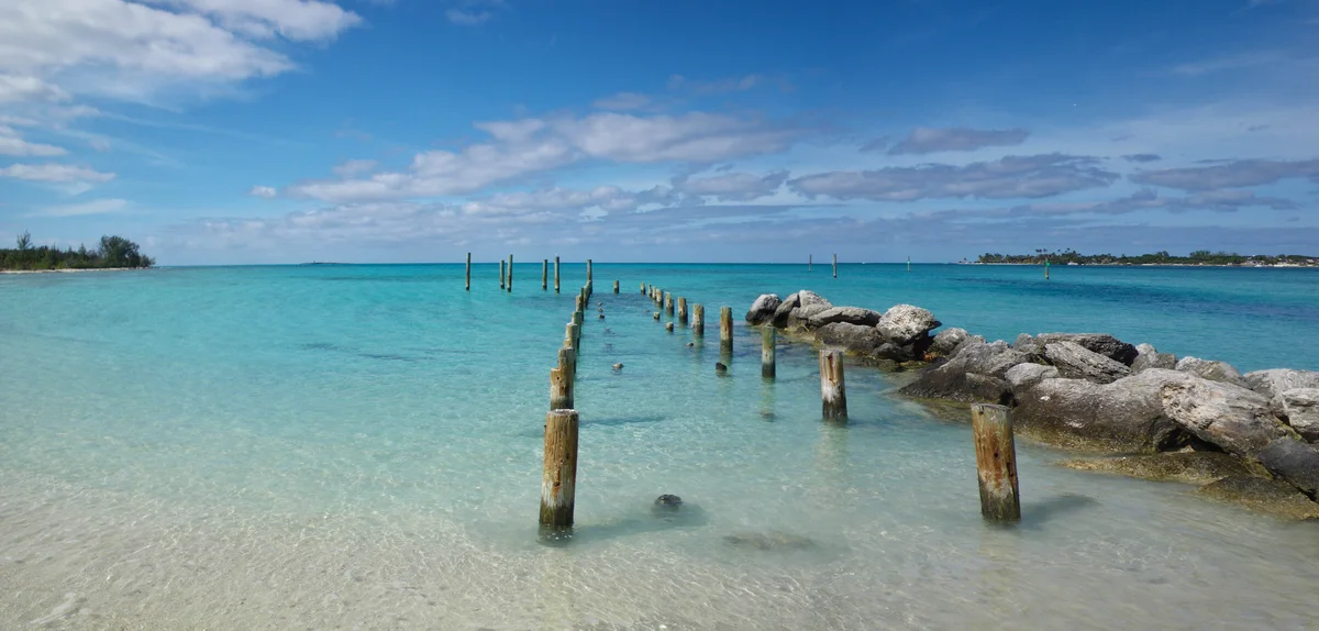 Turquoise water and old pier posts at Jaws Beach, New Providence, Bahamas
