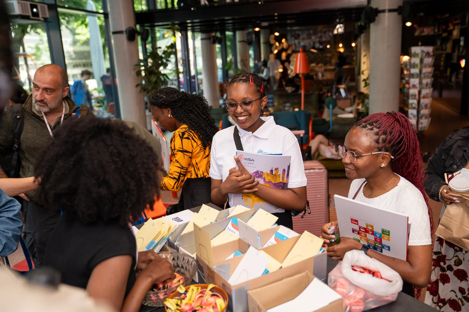 Smiling delegates collecting materials at the WSA Global Congress registration desk.